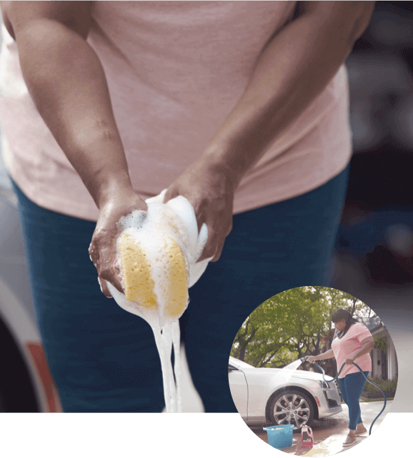 Woman Squeezing a Sponge to Wash a Car
