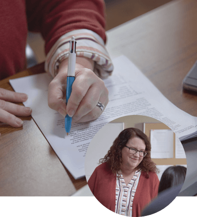 Woman Smiling and Holding Pen to Paper