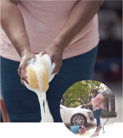 Woman Squeezing a Sponge to Wash a Car